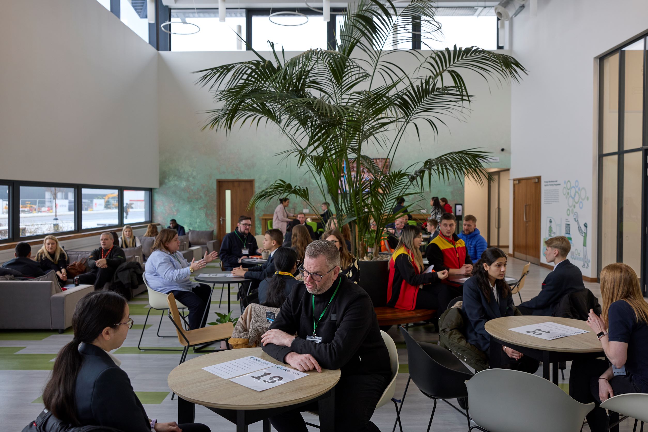 Group of students sat around tables networking for Careers week