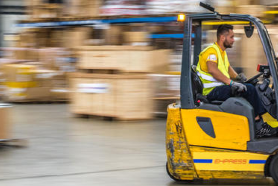 A yellow forklift operated by a man in motion