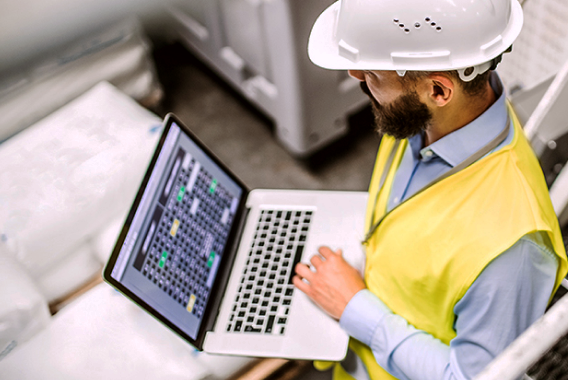 Worker with white hard hat and laptop