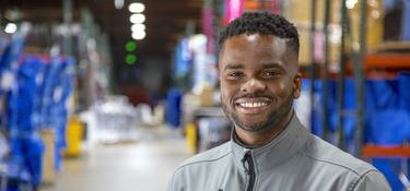 A man in a Prologis jacket smiling at the camera in a warehouse