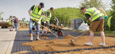 Prologis team members raking dirt for a community project