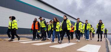 Students dressed in reflective clothing walking down a street