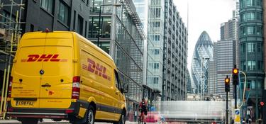 A DHL van driving in a city