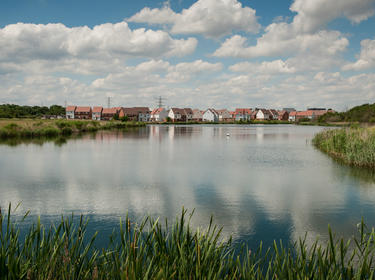 View of The Bridge development across a body of water