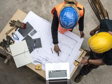 An overhead shot of two people looking at plans