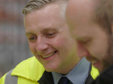 Two men looking down at a laptop