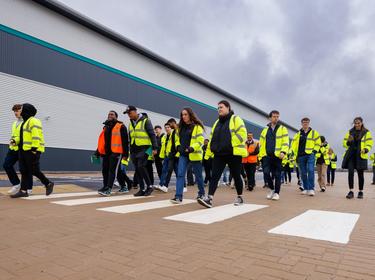 Students dressed in reflective clothing walking down a street