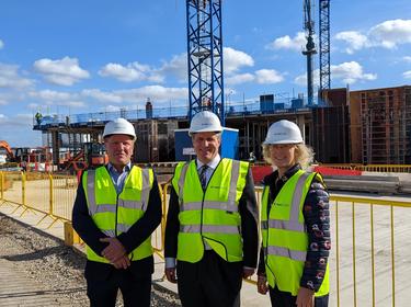 Three Prologis UK team members stand in front of a construction site