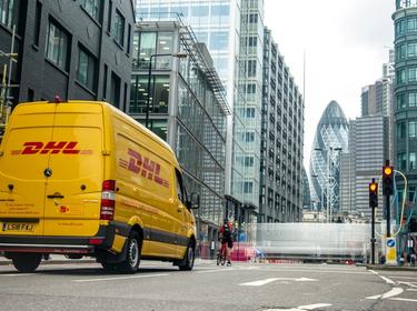 A DHL van driving in a city